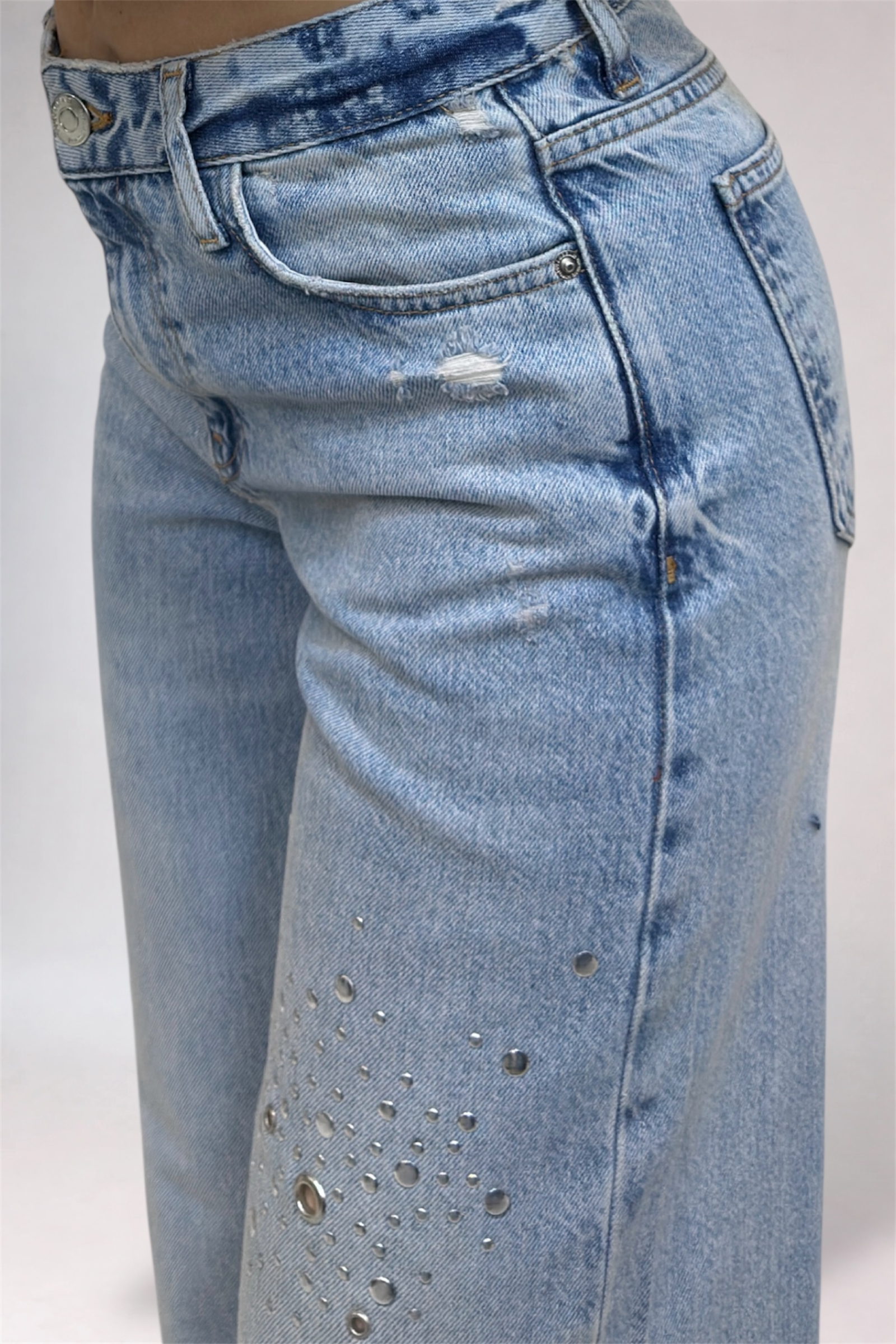 Blue jeans with rhinestone embellishments on a white background