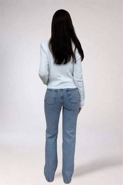 Person wearing light blue jeans and a light gray sweater on a white background