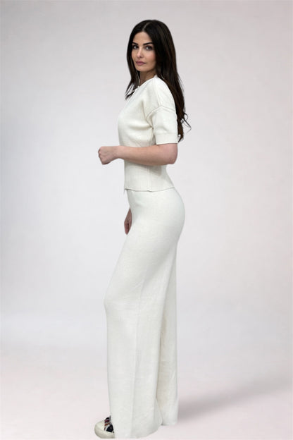 Woman wearing a white outfit on a plain background