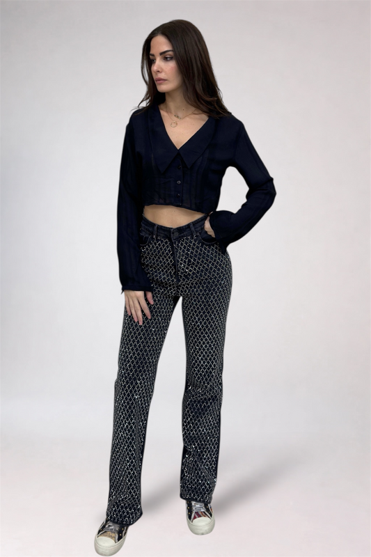 Woman wearing a dark blue cropped jacket and patterned pants on a white background