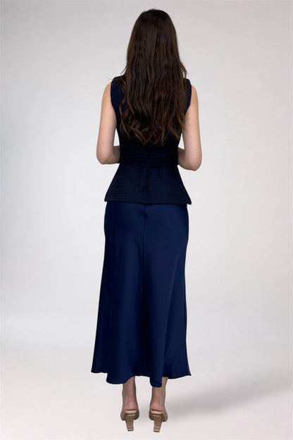 Woman wearing a navy blue sleeveless top and skirt set on a white background