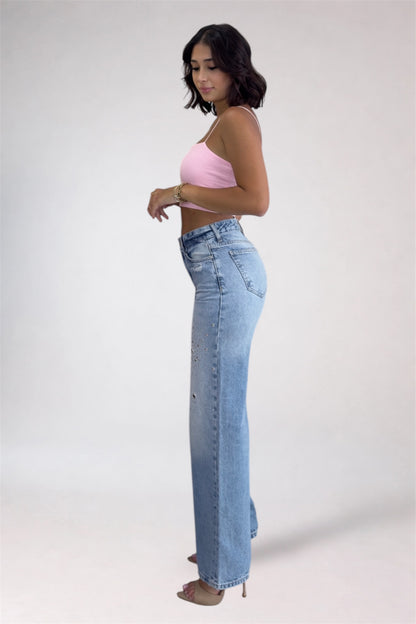 Woman wearing a pink top and light blue jeans on a white background