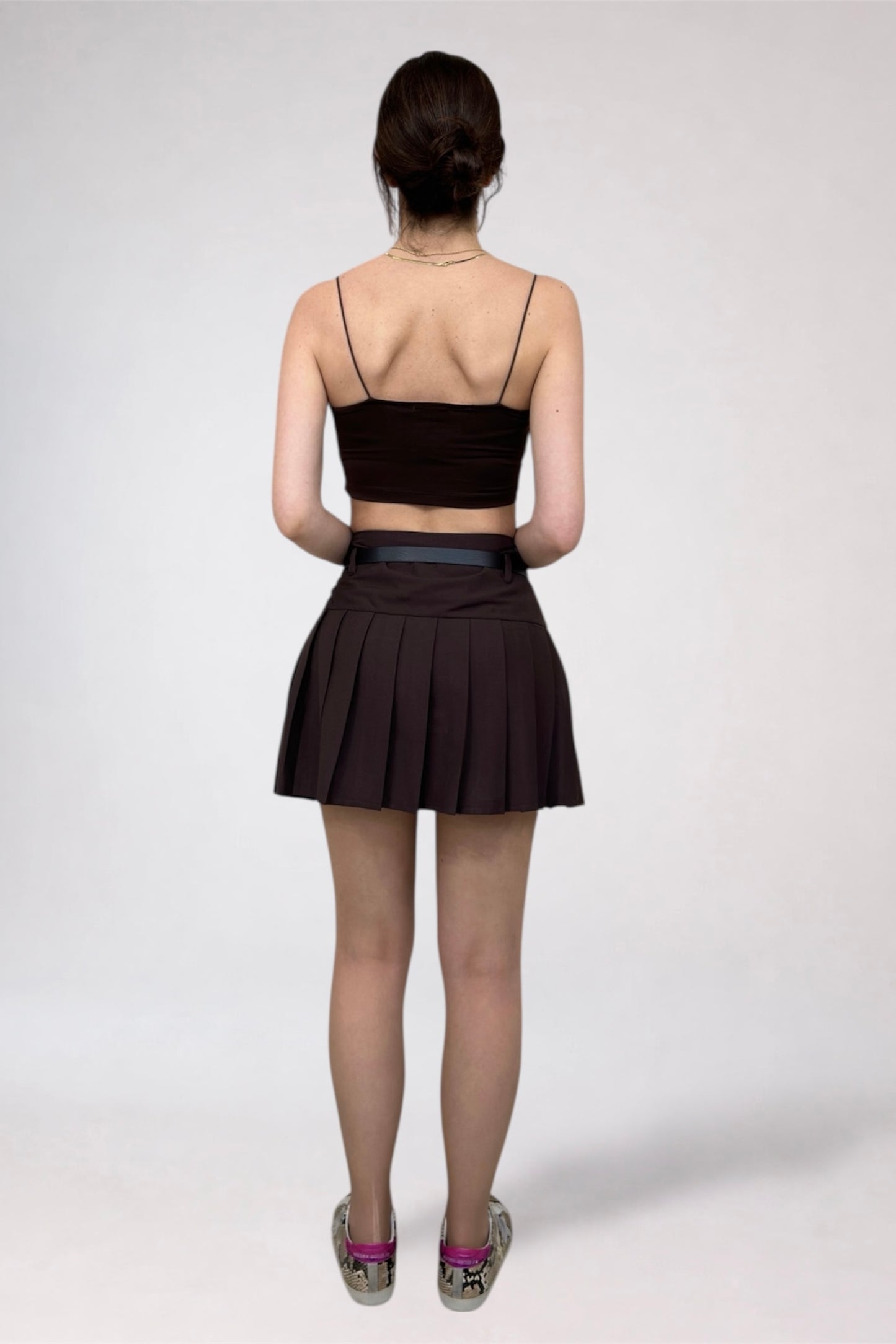 Person wearing a black top and skirt on a white background