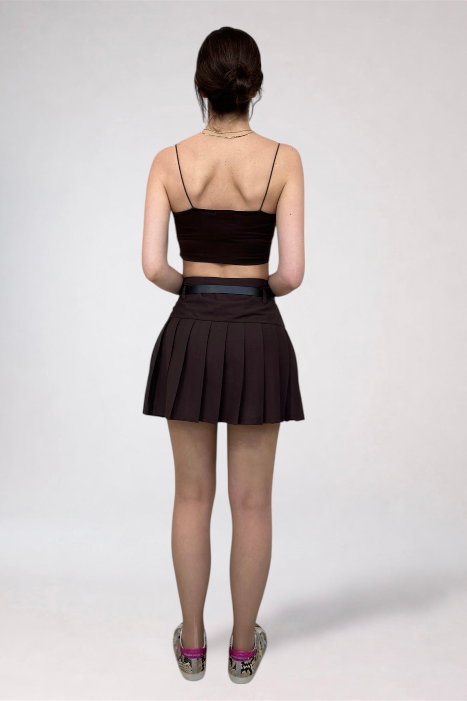 Person wearing a black top and skirt on a white background