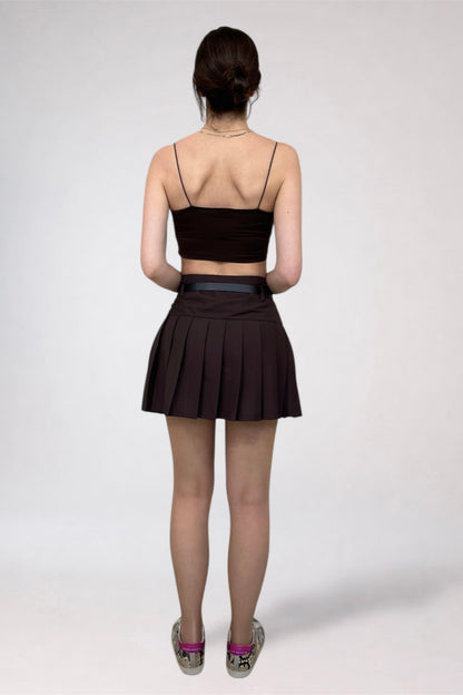 Person wearing a black top and skirt on a white background