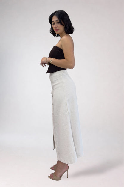 Woman wearing a black top and white pants on a white background