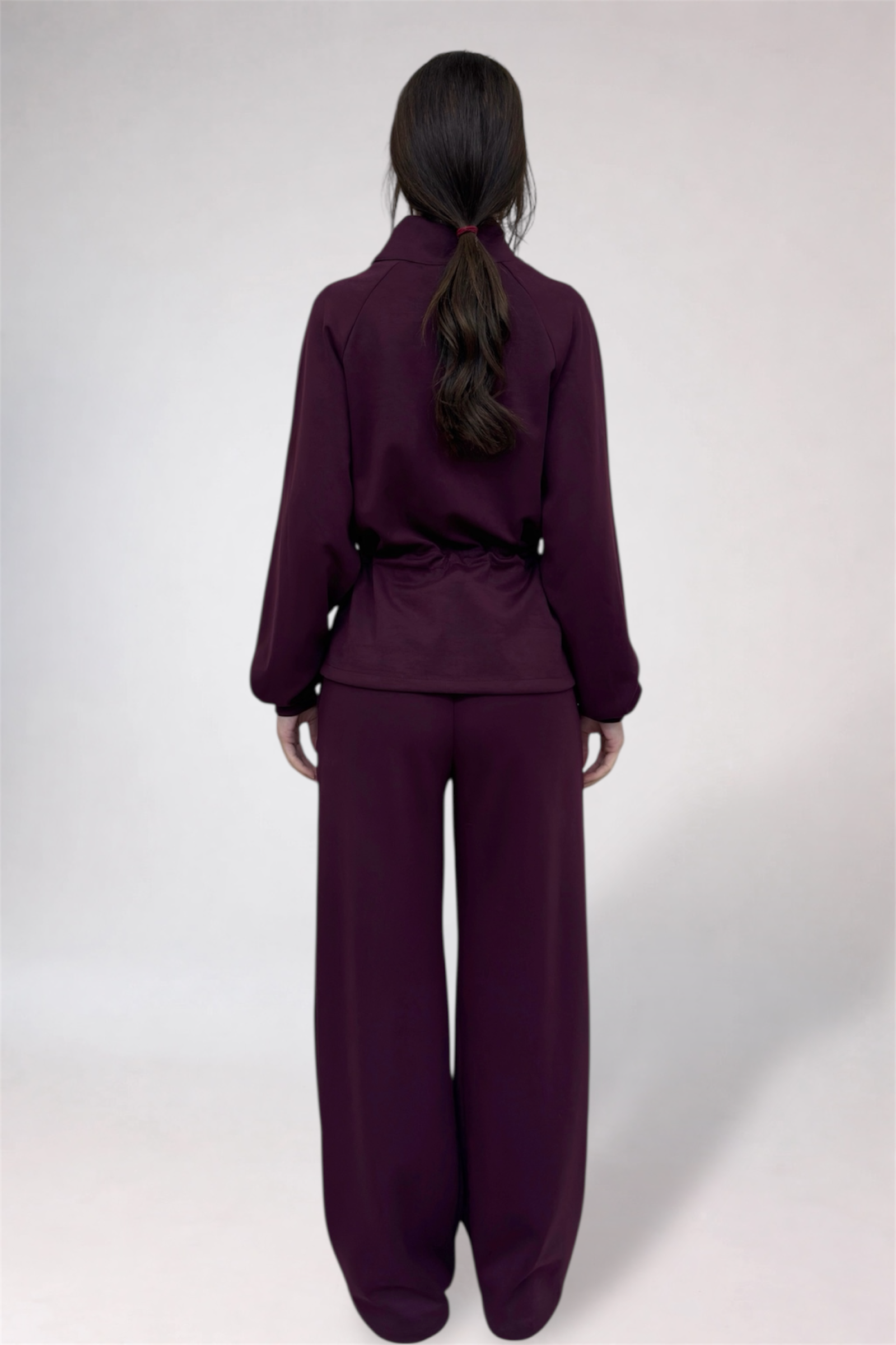 Person wearing a purple outfit on a white background