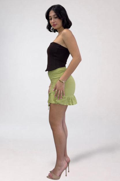 Woman wearing a black top and green skirt on a white background