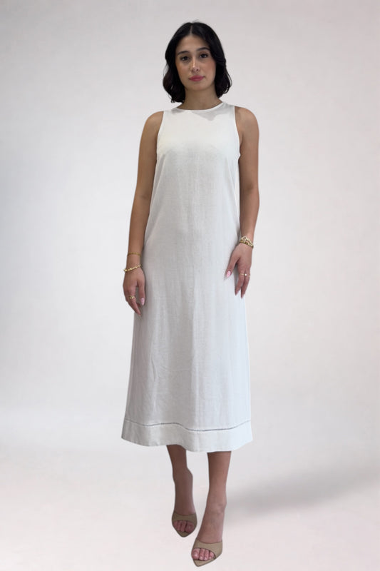 Woman wearing a white sleeveless dress on a plain background