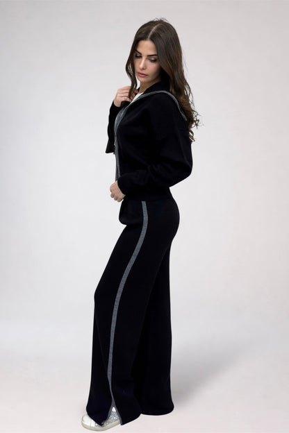 Woman wearing a black tracksuit with white stripes on a white background