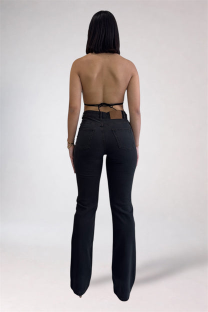Person wearing black high-waisted pants with a strapless top on a white background