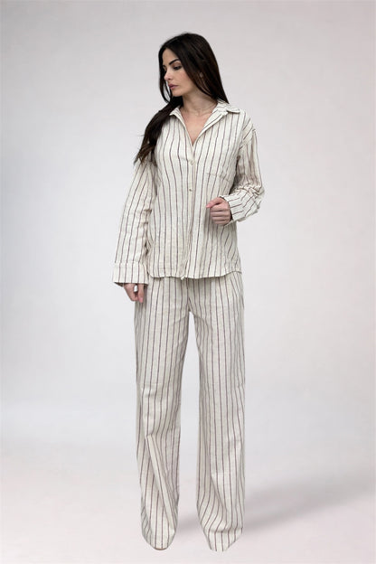 Woman wearing a striped pajama set on a white background