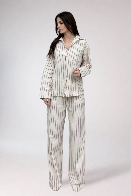 Woman wearing a striped pajama set on a white background