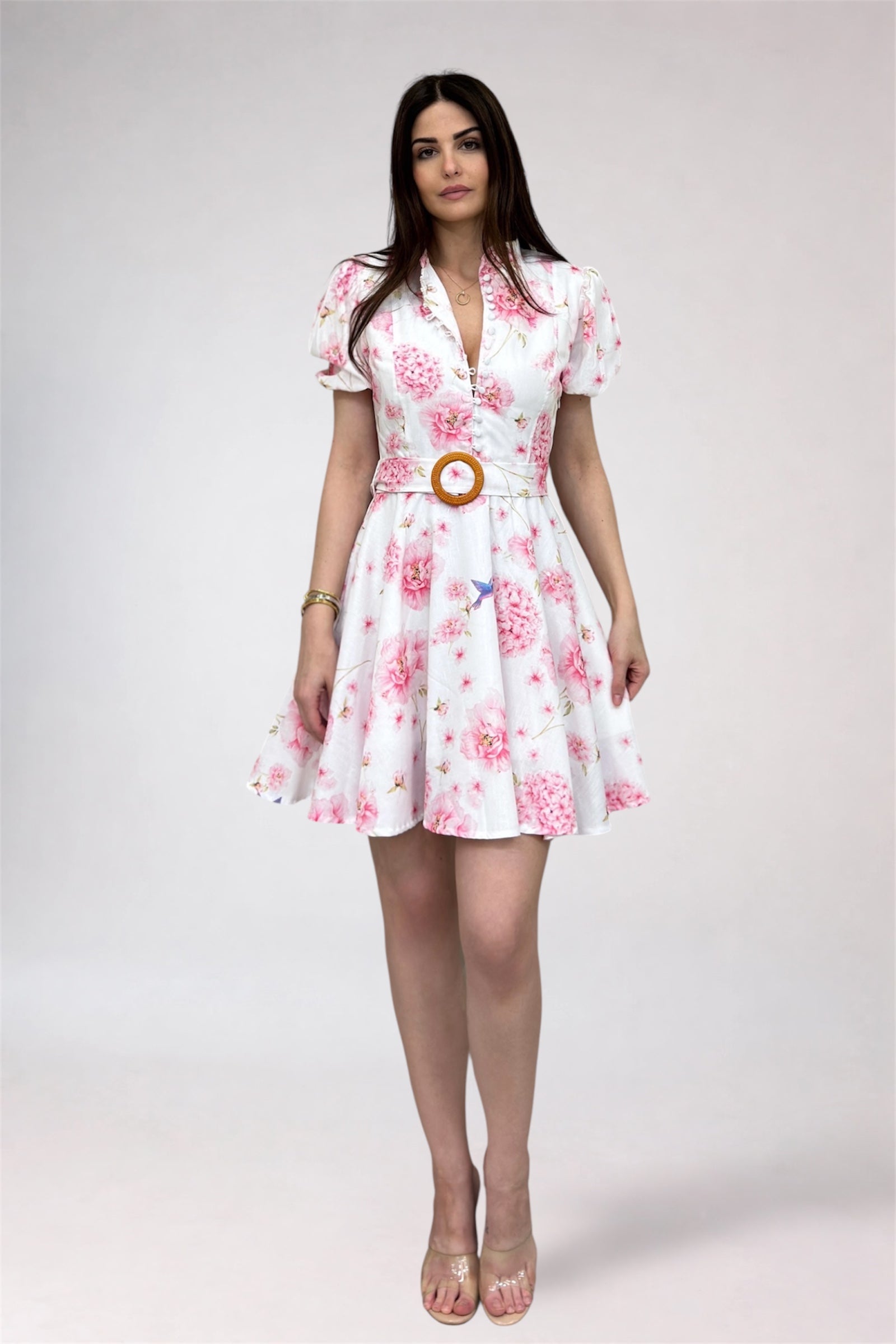 Woman wearing a floral dress with a belt on a white background