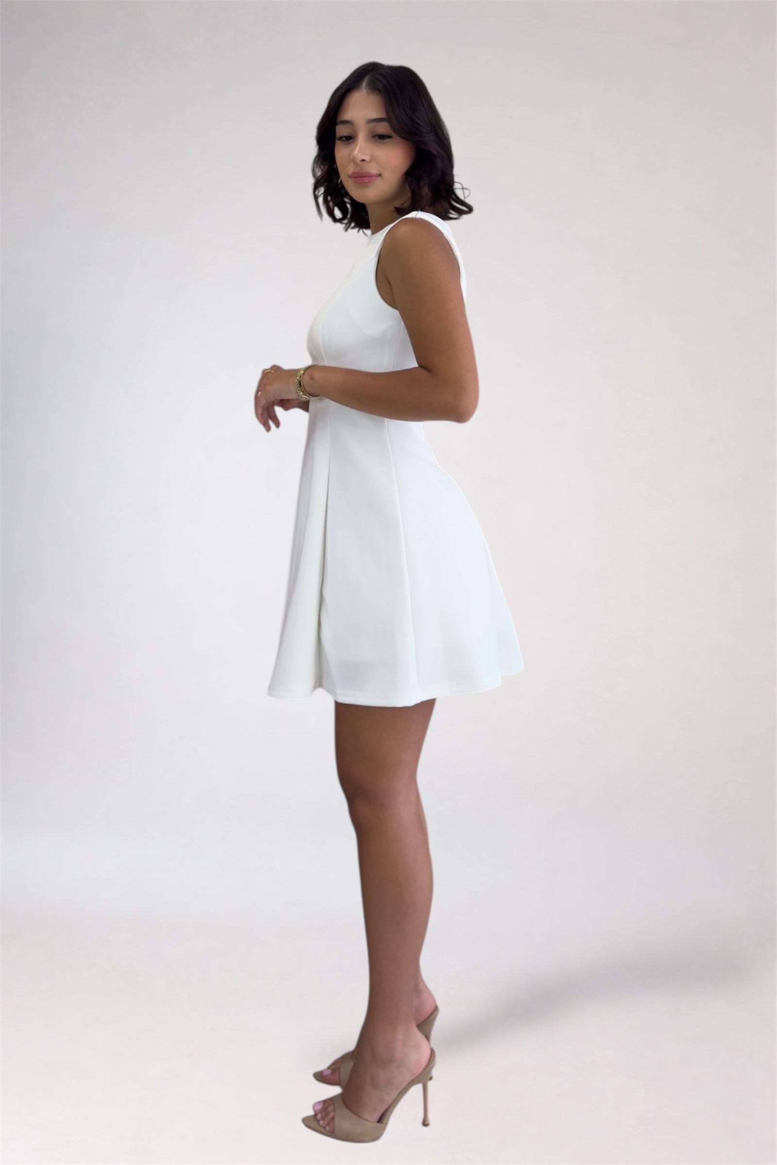 Woman wearing a white dress on a plain background