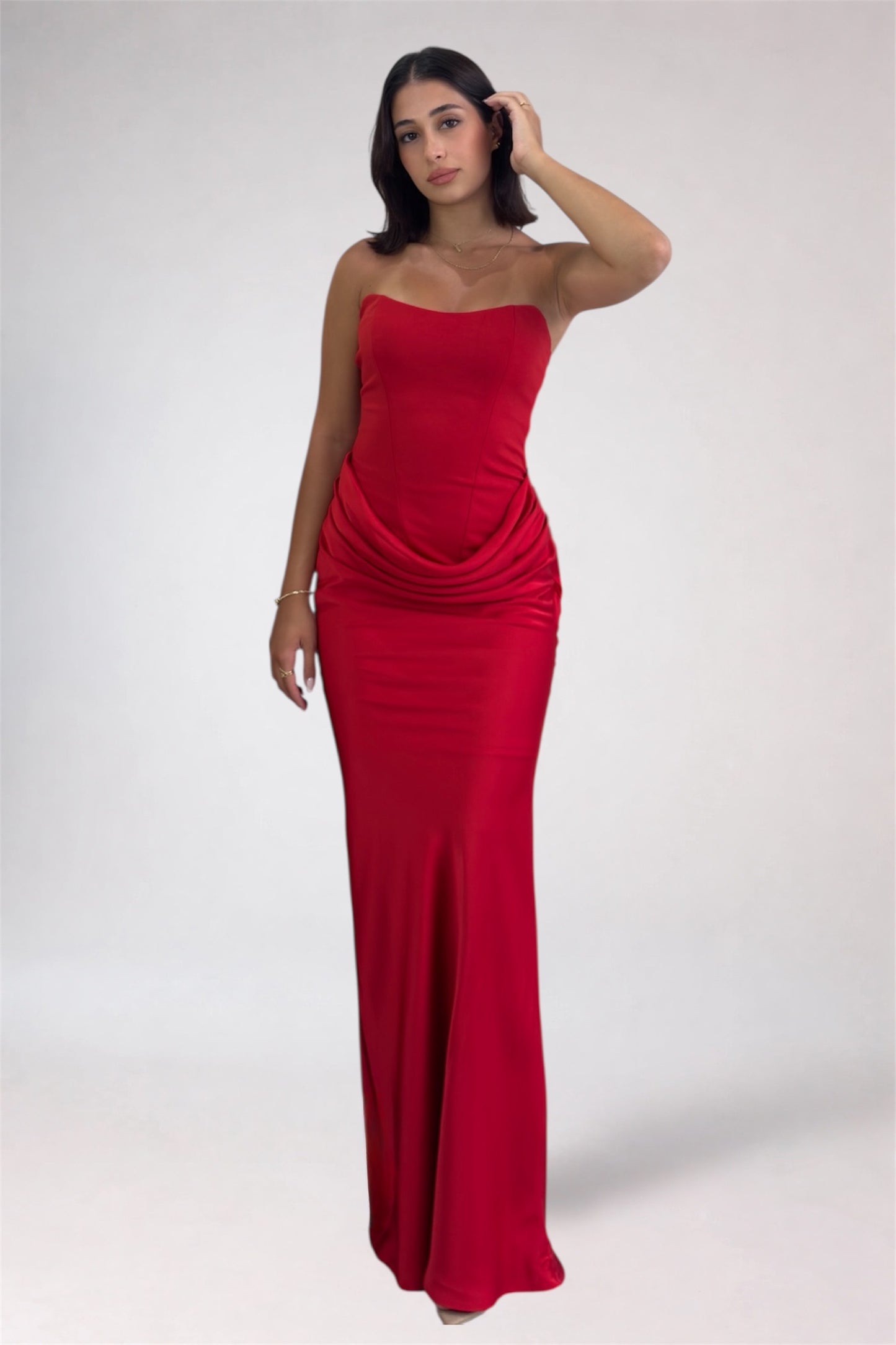 Woman wearing a red strapless gown on a white background