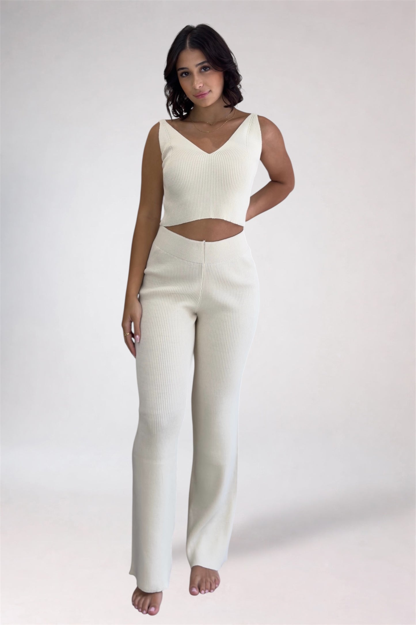 Woman wearing a white outfit on a plain background