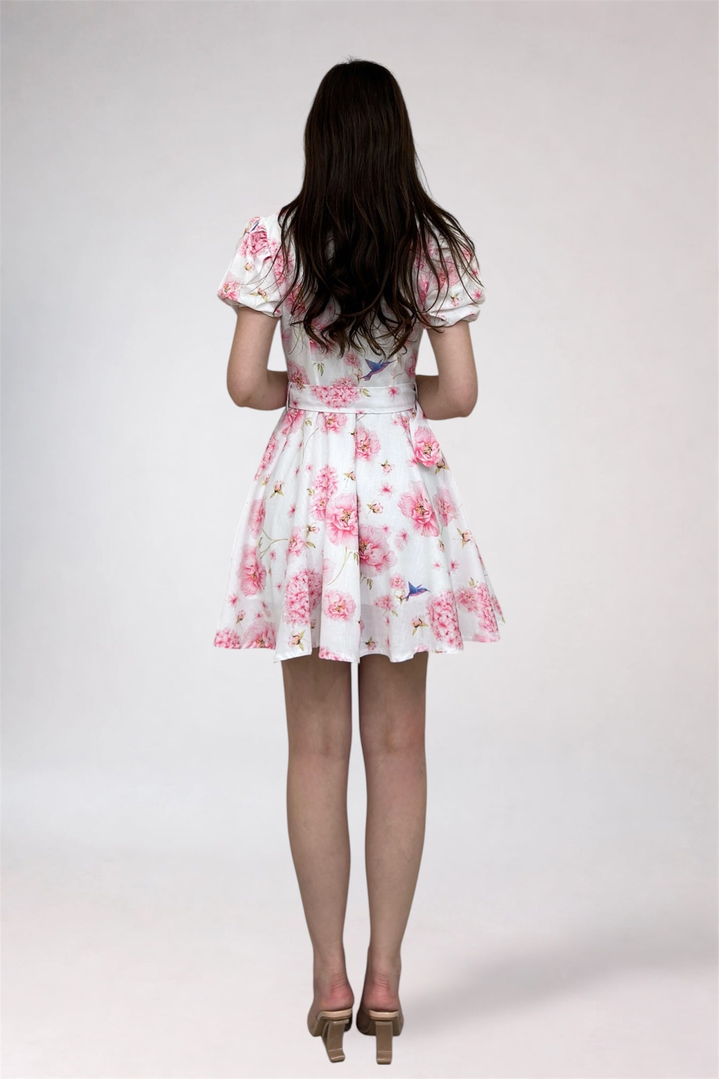 Woman wearing a floral dress on a plain background
