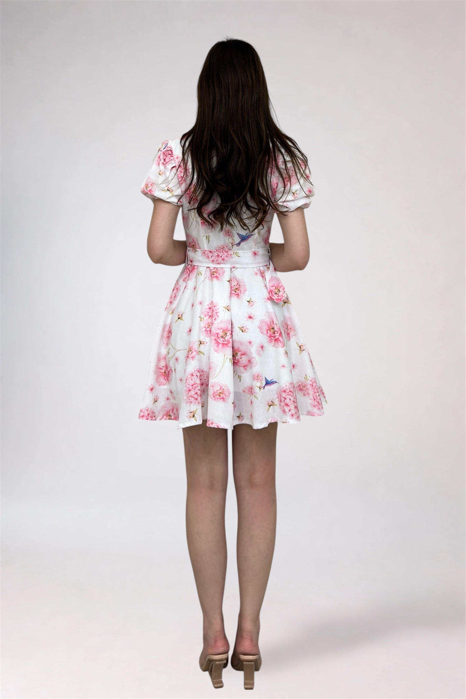 Woman wearing a floral dress on a plain background