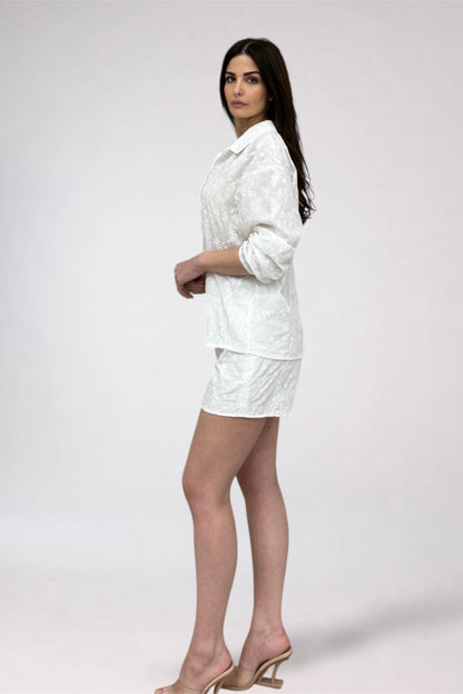 Woman wearing a white outfit on a plain background