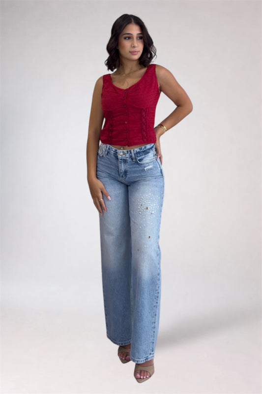 Woman wearing a red top and light blue jeans on a white background