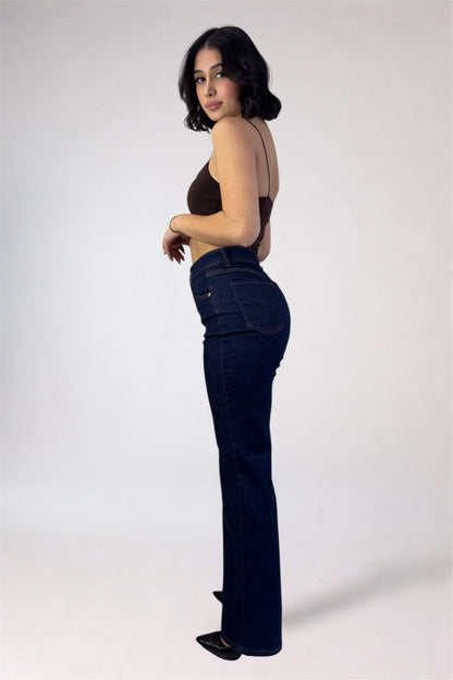 Woman wearing dark blue jeans and a brown top on a white background