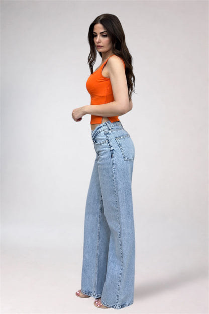 Woman wearing an orange top and light blue jeans on a white background