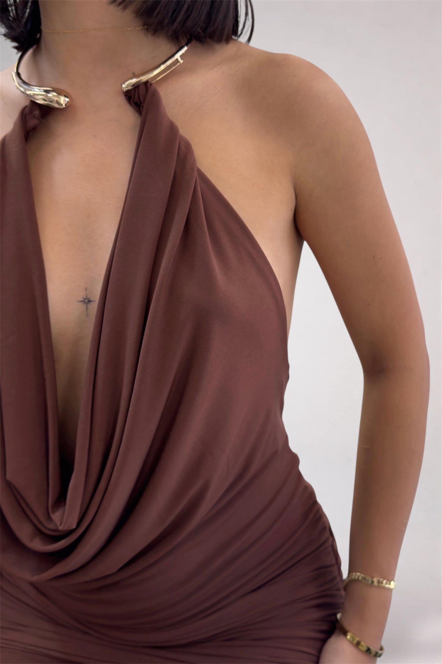 Brown halter neck dress worn by a person on a white background