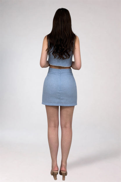 Woman wearing a light blue two-piece outfit on a white background