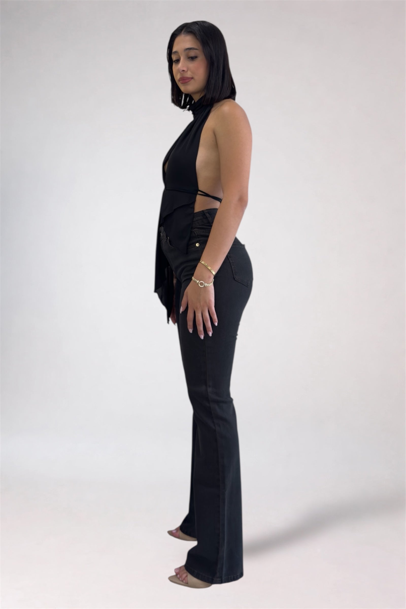 Woman wearing a black outfit with cut-out details on a white background