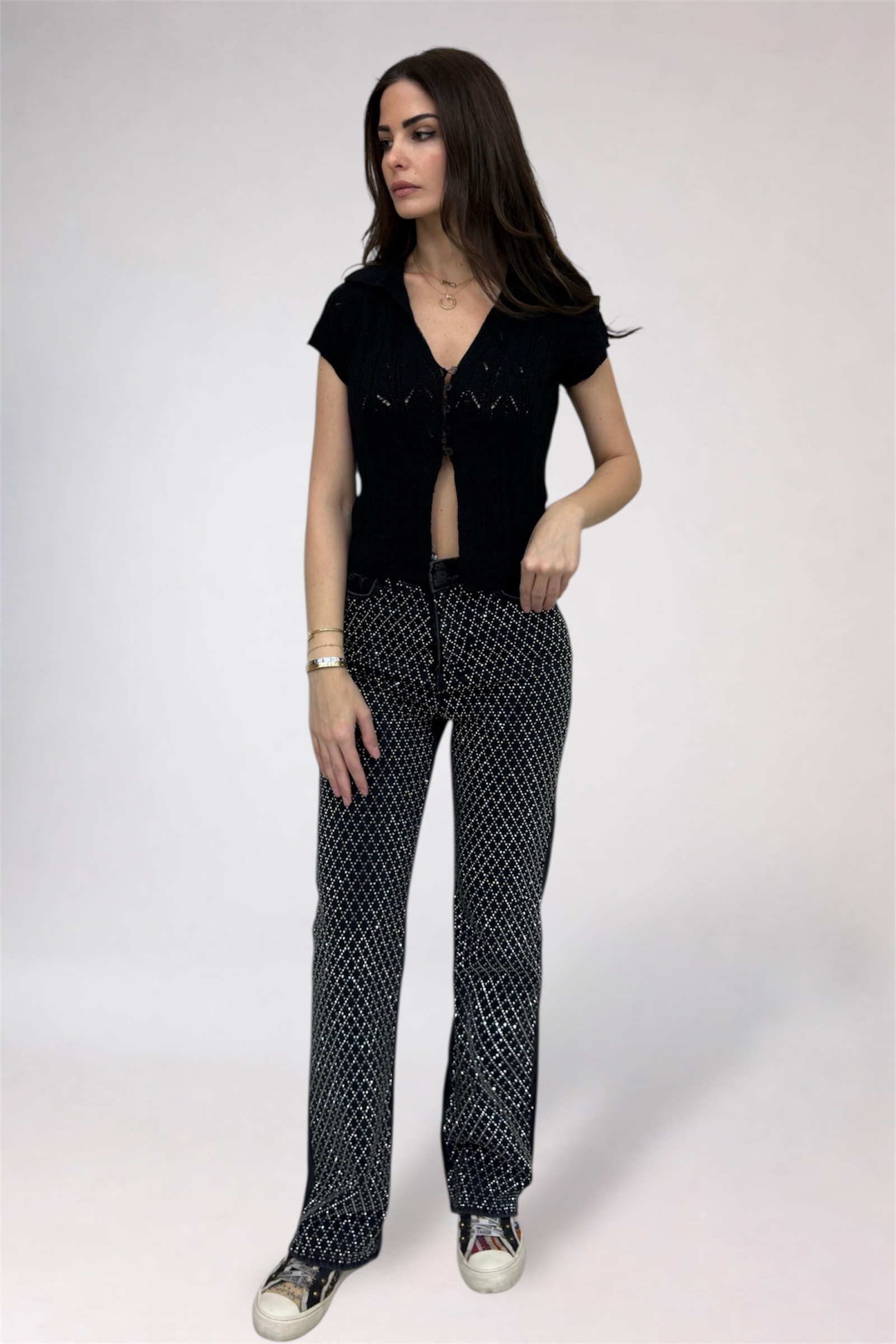 Woman wearing a black top and patterned pants on a white background