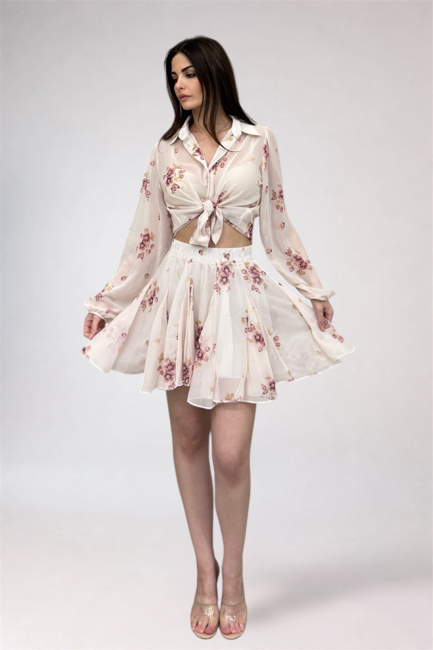 Woman wearing a floral dress with long sleeves on a white background