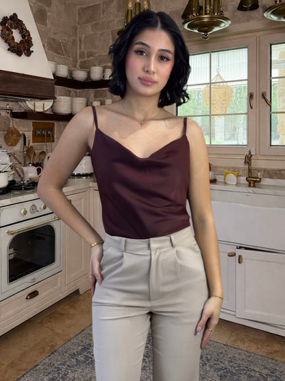 Woman in a kitchen wearing a brown top and beige pants