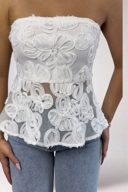White lace strapless top worn by a person against a neutral background