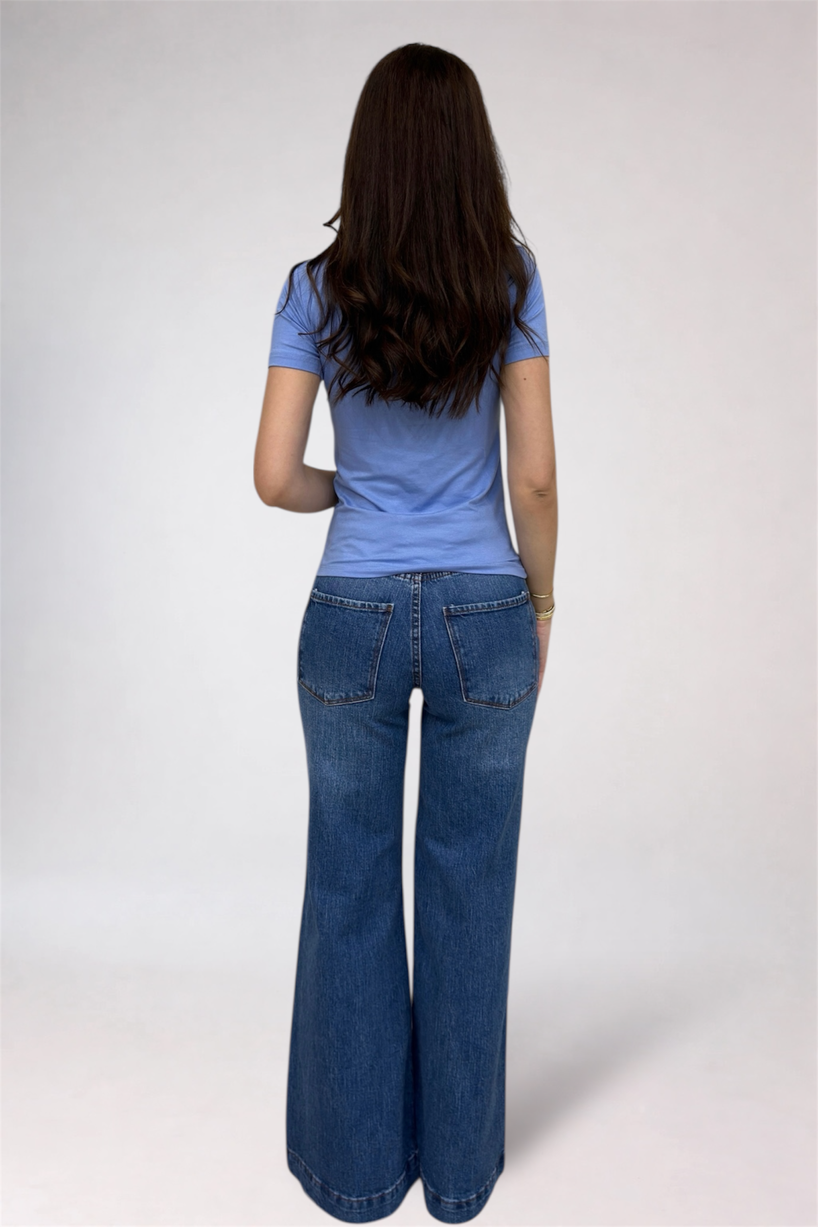 Person wearing a blue shirt and blue jeans on a white background