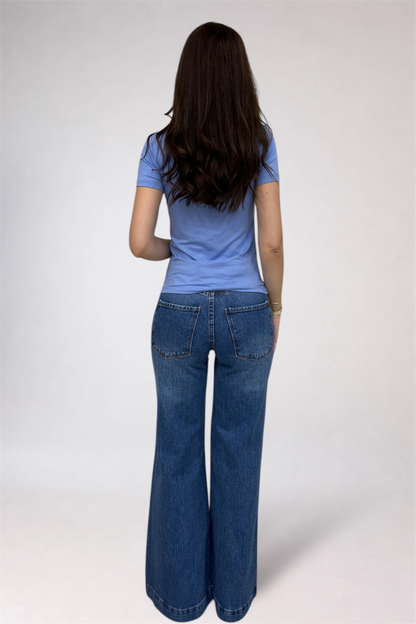 Person wearing a blue shirt and blue jeans on a white background
