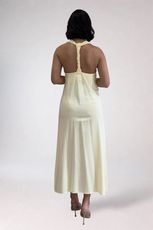 Woman wearing a light-colored dress with a plain background