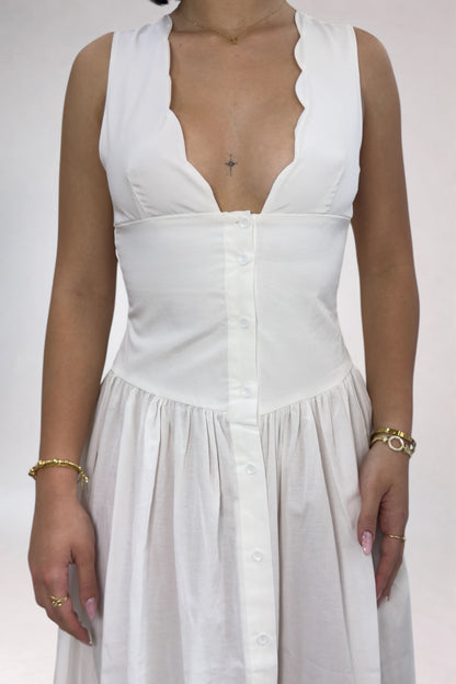 White sleeveless dress with a plunging neckline on a plain background