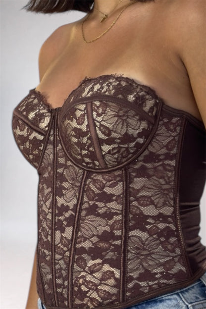 Brown lace corset worn by a person on a white background