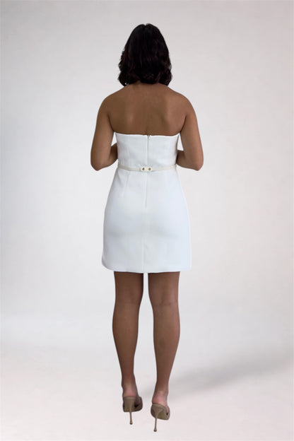 Person wearing a white strapless dress on a plain background