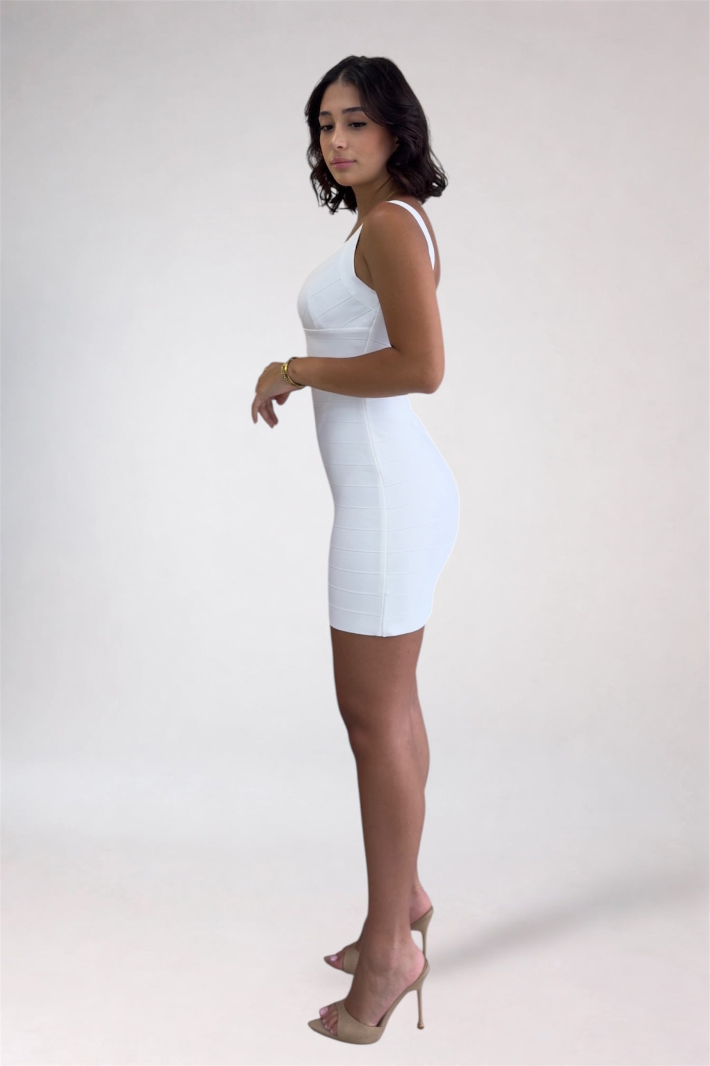 Woman wearing a white dress against a plain background