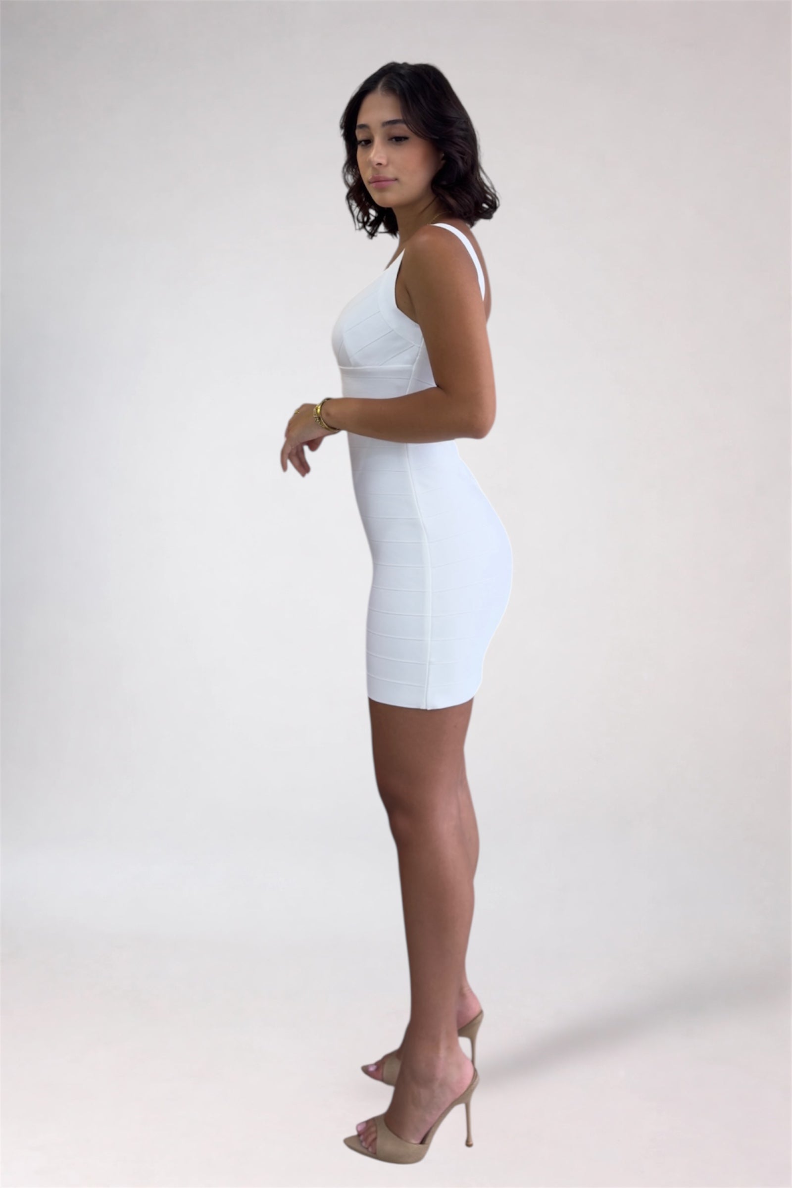 Woman wearing a white dress against a plain background