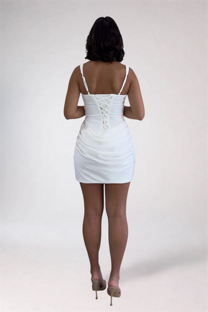 Person wearing a white dress with lace-up back on a plain background