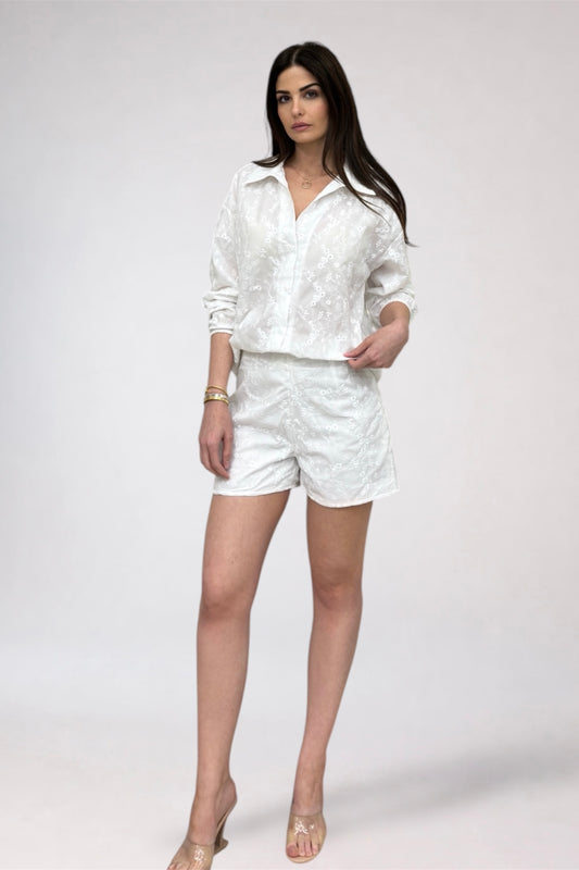 Woman wearing a white outfit on a plain background