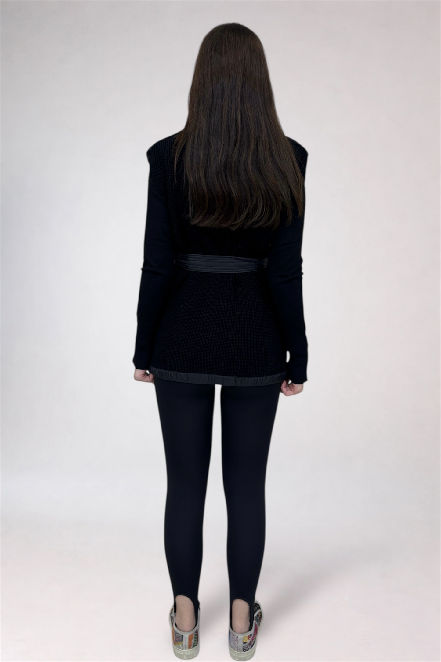 Person wearing a black jacket and pants on a white background