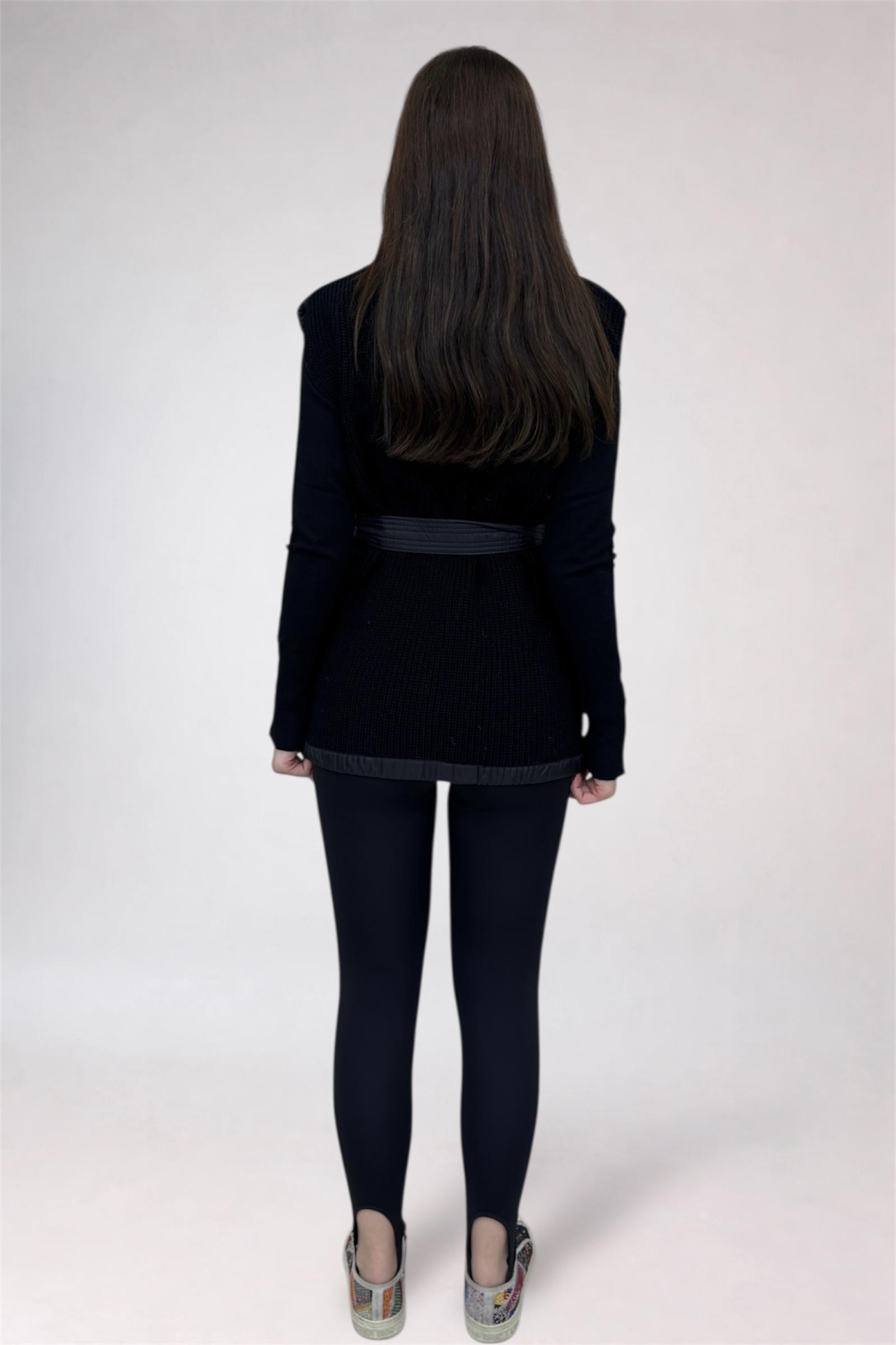 Person wearing a black jacket and pants on a white background