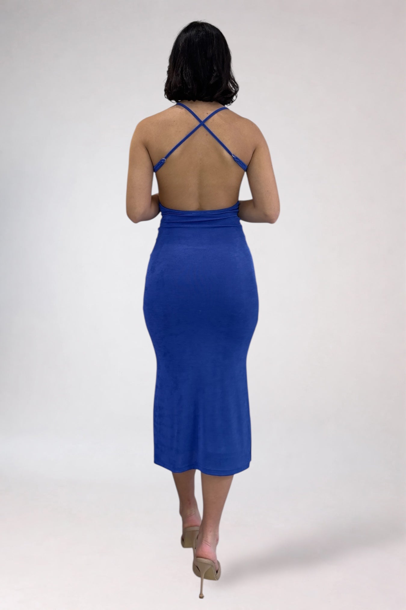 Woman wearing a blue dress with thin straps on a white background