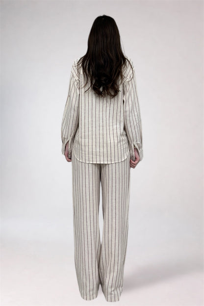 Person wearing a striped pajama set on a white background