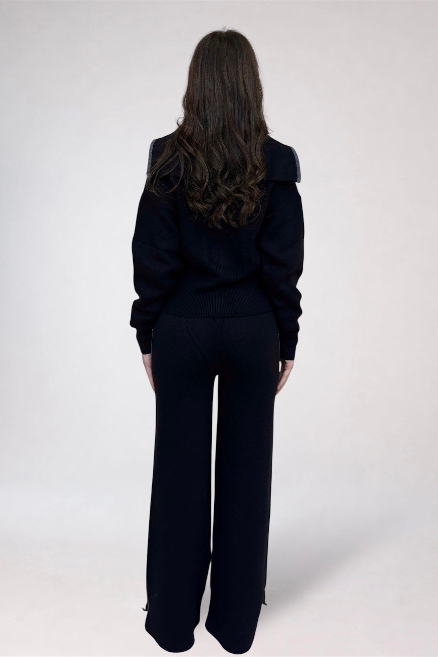 Person wearing a black outfit on a white background