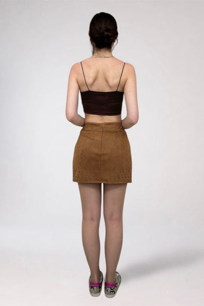 Person wearing a brown top and skirt on a white background